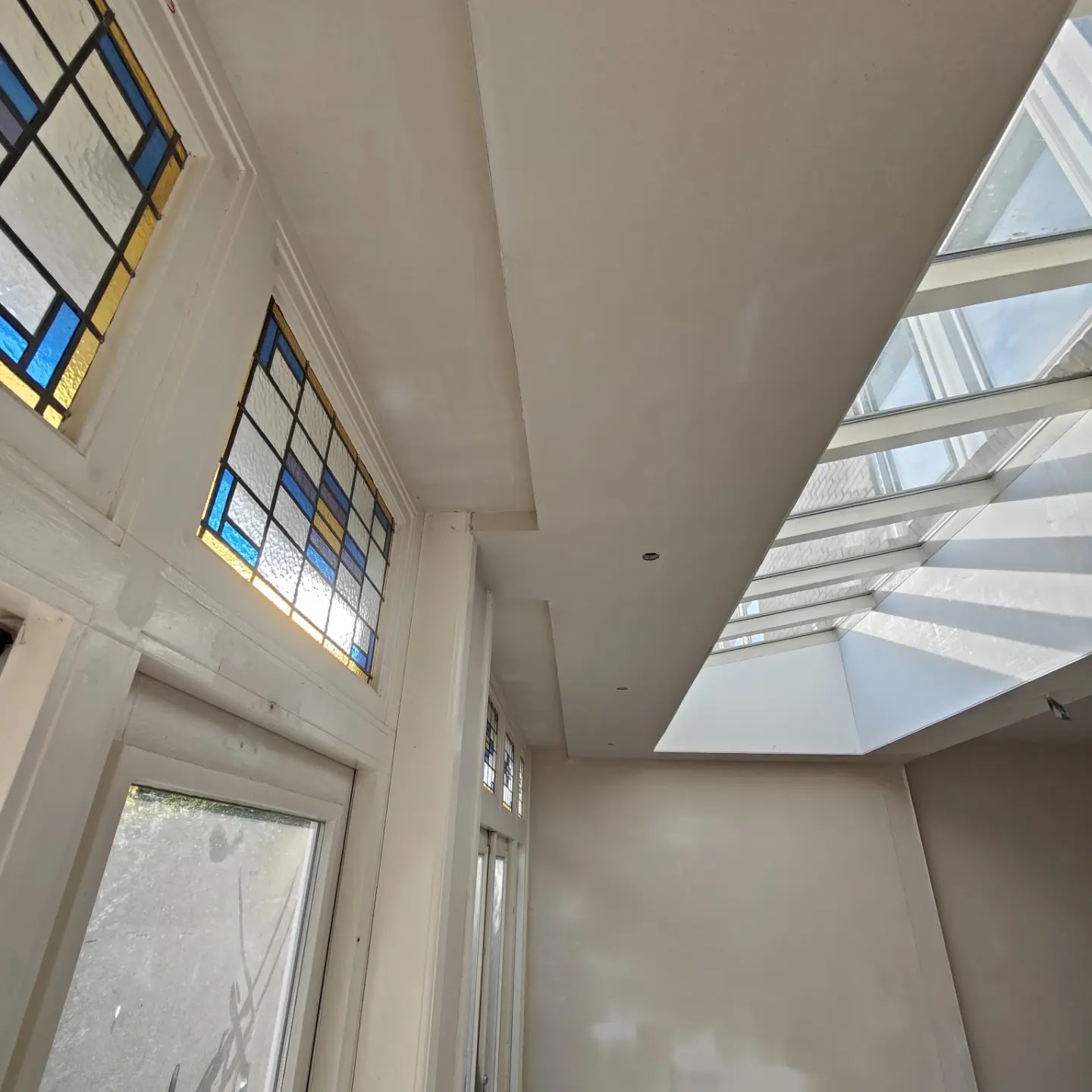 Plafond met glas-in-loodramen en daklicht, strak afgewerkt